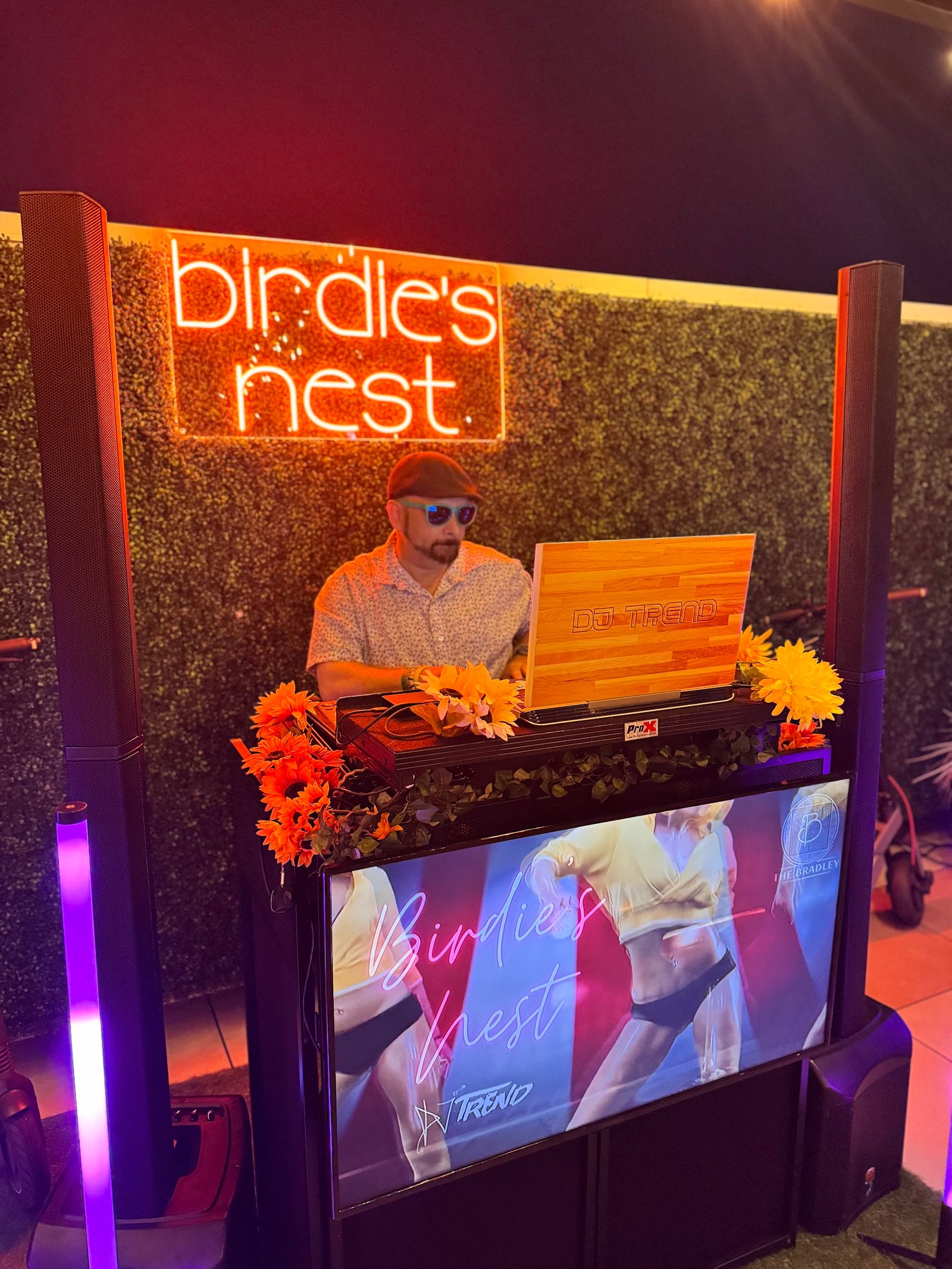 DJ TREND performing at a colorful DJ booth